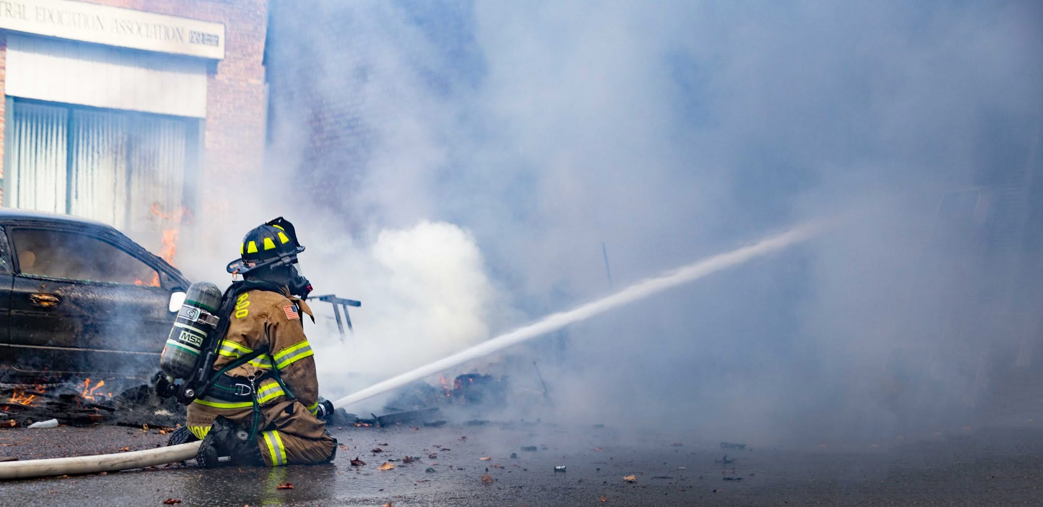 Baraboo firefighter operating a hose line at a vehicle fire.