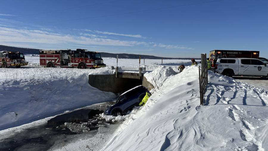 District crews operating at an ice rescue involving a vehicle in a frozen waterway.