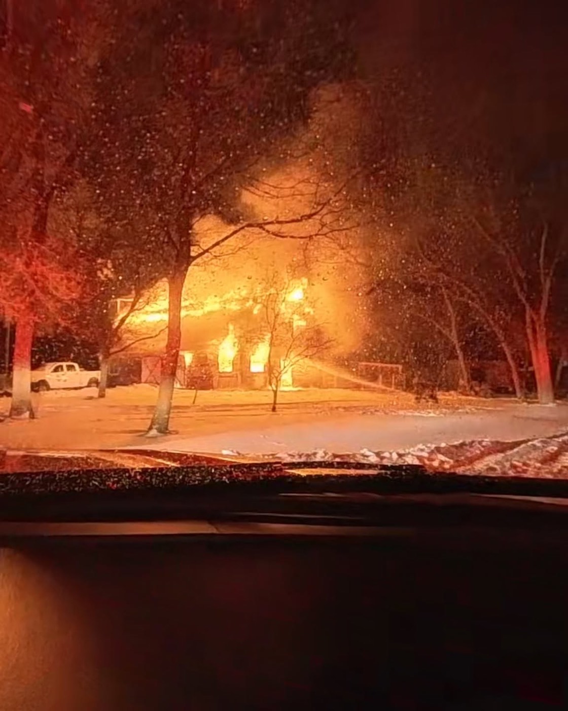 Fire crews directing water onto a fully involved barn during a nighttime structure fire in the Town of Baraboo.